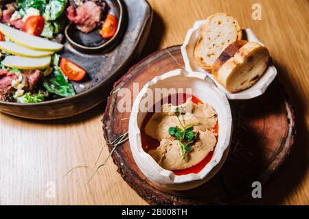 Frische Entenpaß wird mit roter Soße serviert.DANEBEN WIRD ein Teller gebratenes Brot serviert. Stockfoto