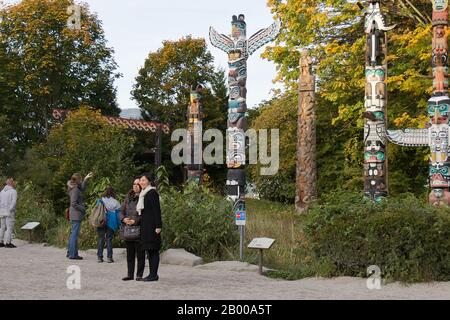 Vancouver, Kanada - 18. November 2019: Touristen fotografieren in der Nähe des beliebten Ortes Totem Pole im Stanley Park während der Herbstsaison Stockfoto