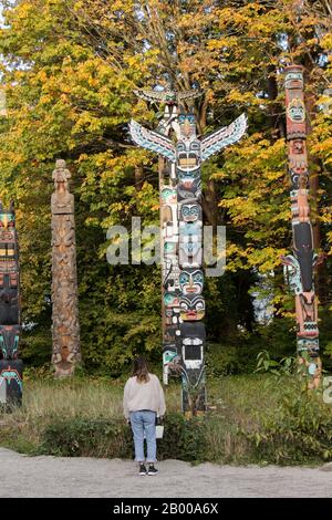 Vancouver, Kanada - 18. November 2019: Ein Tourist betrachtet Totem Poles im Stanley Park während der Herbstsaison Stockfoto