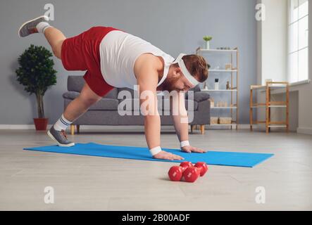 Lustiger Yoga. Fetter Mann, der Yoga-Übungen im Raum macht. Stockfoto