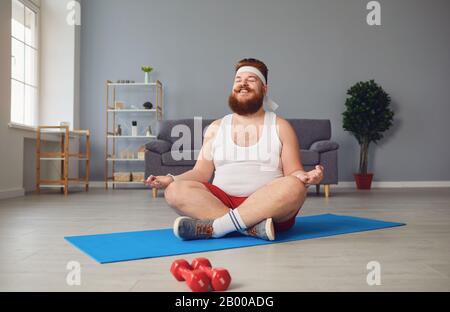 Lustiger Yoga. Fetter Mann, der Yoga-Übungen im Raum macht. Stockfoto