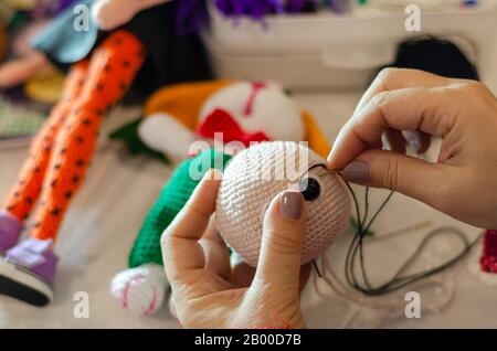 Buntes Häkelkaninchen machen. Das Spielzeug für Babys oder Trinket. Auf dem Tisch Fäden, Nadeln, Haken, Baumwollgarn. Handgemeltes Geschenk. Stockfoto