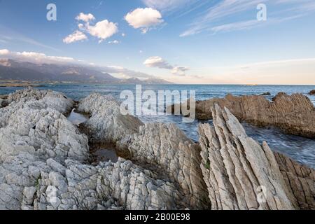 Felsenküste auf der Kaikoura-Halbinsel, Berge der Kaikoura Range im Hintergrund, Kaikoura, Canterbury, South Island, Neuseeland Stockfoto