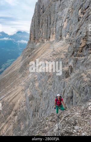 Junge Frau, Wanderer mit Kletterhelm auf einer Felswand Gesichert, Über Ferrata Francesco Berti, Sorapiss-Rundkurs, in den Dolmen, Belluno, Italien Stockfoto