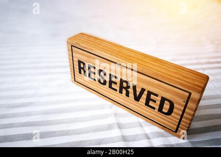 Reservierter Tisch. Reserviertes Holzschild auf dem Tisch für die Reservierung. Reservierter Tisch im Restaurant. Stockfoto