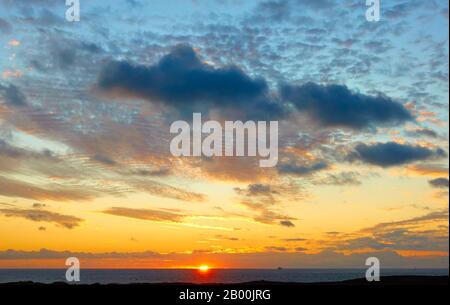 Die Sonne steht kurz vor dem Untergehen des Meereshorizonts. Sunset Landscape - saisonale Hintergrundinformationen mit Platz für Ihren eigenen Text Stockfoto