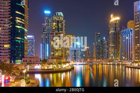 Moderne Wolkenkratzer von Dubai Marina in der Nacht und ihre Reflexionen im Wasser, Vereinigte Arabische Emirate Stockfoto