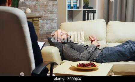 Erfolgreicher junger Mann, der über die Probleme in seiner Beziehung zur Frau spricht. Paartherapie. Stockfoto