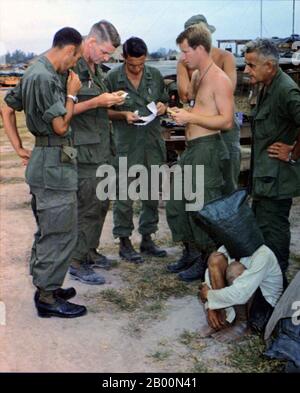 Vietnam: Ein Verdächtiger des NLF (Viet Cong), der 1968 bei einem Angriff auf einen amerikanischen Außenposten nahe der kambodschanischen Grenze in Südvietnam gefangen genommen wurde, wird verhört. Die Vietcong (vietnamesisch: Việt cộng), oder National Liberation Front (NLF), war eine politische Organisation und Armee in Süd-Vietnam und Kambodscha, die die Vereinigten Staaten und Süd-vietnamesischen Regierungen während des Vietnamkrieges (1955-1975) bekämpft. Sie hatte sowohl Guerilla- als auch reguläre Armeeeinheiten, sowie ein Netzwerk von Kadern, die Bauern auf dem von ihr kontrollierten Gebiet organisierten. Viele Soldaten wurden in Südvietnam rekrutiert. Stockfoto