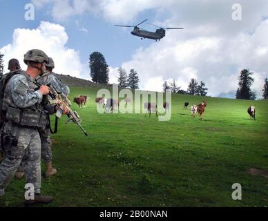 Afghanistan: Ein Soldat der Hauptquartiere und Hauptquartiertruppen, 1. Geschwader, 91. Kavallerieregiment (Airborne), beobachtet, wie Rinder Platz machen, während ein CH-47 Hubschrauber sich vorbereitet, auf Landezone Shetland zu landen während der Operation Saray hat Juli 19 nahe Vorwärts Operationsbasis Naray, Afghanistan. (USA Armee Foto von Sgt. Brandon Aird, in Public Domain). Stockfoto