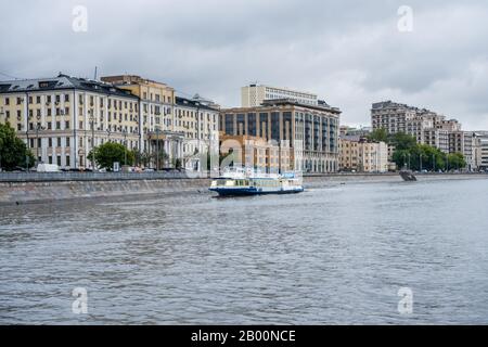 Moderne Gebäude am Ufer der Moskwa, Moskau, Russland. Ansicht bilden Sie ein Kreuzfahrtschiff auf dem Fluss. Stockfoto