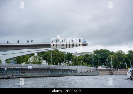 Touristen an der Sichtstelle am Flussufer der Moskwa an einem regnerischen Tag, Moskau, Russland. Ansicht bilden Sie ein Kreuzfahrtschiff auf dem Fluss. Stockfoto