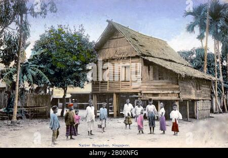 Singapur: Malaiische Kinder und Stelzenhaus im 'Bangalore Village', Postkarte aus Singapur, 1919. Singapur beherbergte 1819 mit Genehmigung des Sultanats Johor einen Handelsposten der East India Company. Die Briten erlangten 1824 die Souveränität über die Insel und Singapur wurde 1826 zu einer der britischen Straits-Siedlungen. Im Zweiten Weltkrieg von den Japanern besetzt, erklärte Singapur die Unabhängigkeit und Vereinigte sich 1963 mit anderen ehemaligen britischen Territorien zu Malaysia, obwohl es zwei Jahre später von Malaysia getrennt wurde und zu einem der erfolgreichen vier asiatischen Tiger wurde. Stockfoto