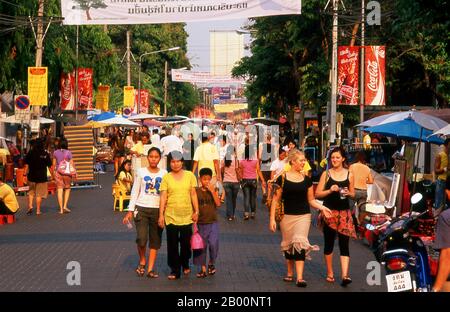 Thailand: Thais und Ausländer genießen Chiang Mai's Sunday Walking Street Market, Chiang Mai. Chiang Mai wird oft als Thailands ‘Rose des Nordens’ bezeichnet und ist die zweite Stadt des Landes und ein beliebtes Touristenziel vor allem wegen seiner bergigen Landschaft, bunten ethnischen Bergstämmen und ihrem Kunsthandwerk. 1296 von König Mengrai als Hauptstadt seines Lanna-Königreichs gegründet, wurde Chiang Mai 1767 von burmesischen Invasoren überrannt. Die Stadt wurde dann verlassen zwischen 1776 und 1791. Chiang Mai wurde offiziell Teil von Siam in 1774 durch eine Vereinbarung mit lokalen Prinz Chao Kavila. Stockfoto