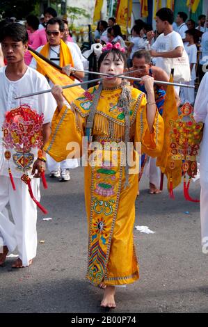 Thailand: Ein weibliches 'Ma Song' in der Parade der Devotees, Phuket Town, Phuket Vegetarian Festival. Das Vegetarische Festival ist ein religiöses Festival, das jährlich auf der Insel Phuket im Süden Thailands stattfindet. Es zieht Massen von Zuschauern wegen vieler der ungewöhnlichen religiösen Rituale an, die durchgeführt werden. Viele religiöse Anhänger werden sich mit Schwertern niederschlagen, ihre Wangen mit scharfen Gegenständen durchbohren und andere schmerzhafte Handlungen begehen. Stockfoto