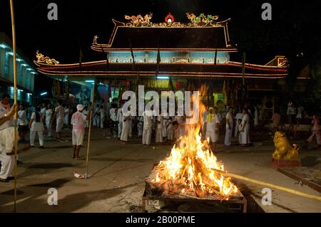 Thailand: Ein Scheiterhaufen für glückliche Papierfahnen am San Chao Bang Niew (chinesischer Taoist-Tempel), Phuket Vegetarian Festival. Das Vegetarische Festival ist ein religiöses Festival, das jährlich auf der Insel Phuket im Süden Thailands stattfindet. Es zieht Massen von Zuschauern wegen vieler der ungewöhnlichen religiösen Rituale an, die durchgeführt werden. Viele religiöse Anhänger werden sich mit Schwertern niederschlagen, ihre Wangen mit scharfen Gegenständen durchbohren und andere schmerzhafte Handlungen begehen. Stockfoto