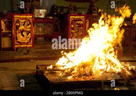 Thailand: Ein Scheiterhaufen für glückliche Papierfahnen am San Chao Bang Niew (chinesischer Taoist-Tempel), Phuket Vegetarian Festival. Das Vegetarische Festival ist ein religiöses Festival, das jährlich auf der Insel Phuket im Süden Thailands stattfindet. Es zieht Massen von Zuschauern wegen vieler der ungewöhnlichen religiösen Rituale an, die durchgeführt werden. Viele religiöse Anhänger werden sich mit Schwertern niederschlagen, ihre Wangen mit scharfen Gegenständen durchbohren und andere schmerzhafte Handlungen begehen. Stockfoto