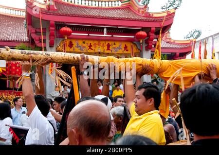 Thailand: Die Absenkung des Laternenpols am San Chao Chui TUI (chinesischer Taoist-Tempel), Phuket Vegetarian Festival. Das Vegetarische Festival ist ein religiöses Festival, das jährlich auf der Insel Phuket im Süden Thailands stattfindet. Es zieht Massen von Zuschauern wegen vieler der ungewöhnlichen religiösen Rituale an, die durchgeführt werden. Viele religiöse Anhänger werden sich mit Schwertern niederschlagen, ihre Wangen mit scharfen Gegenständen durchbohren und andere schmerzhafte Handlungen begehen. Stockfoto