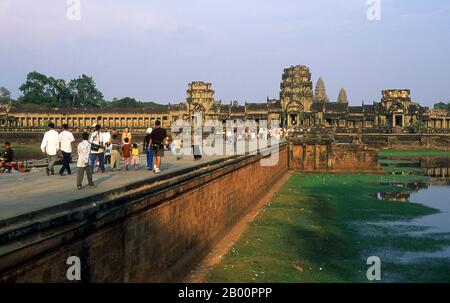 Kambodscha: Menschen auf dem Damm, der nach Angkor Wat führt. Angkor Wat wurde für König Suryavarman II. (Regierte 1113-50) im frühen 12. Jahrhundert als Staatstempel und Hauptstadt erbaut. Als besterhaltener Tempel am Standort Angkor ist er der einzige, der seit seiner Gründung ein bedeutendes religiöses Zentrum geblieben ist – zuerst Hindu, dem gott Vishnu gewidmet, dann Buddhist. Es ist das größte religiöse Gebäude der Welt. Der Tempel ist an der Spitze der hohen klassischen Stil der Khmer-Architektur. Es ist zu einem Symbol Kambodschas geworden, das auf seiner Nationalflagge erscheint. Stockfoto