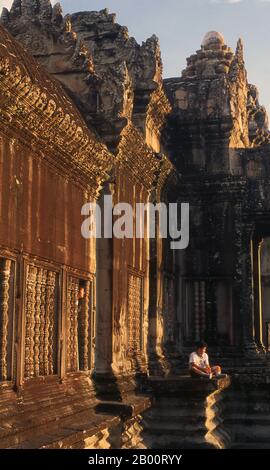 Kambodscha: Der Sonnenuntergang über Angkor Wat von der oberen Ebene des zentralen Heiligtums. Angkor Wat wurde für König Suryavarman II. (Regierte 1113-50) im frühen 12. Jahrhundert als Staatstempel und Hauptstadt erbaut. Als besterhaltener Tempel am Standort Angkor ist er der einzige, der seit seiner Gründung ein bedeutendes religiöses Zentrum geblieben ist – zuerst Hindu, dem gott Vishnu gewidmet, dann Buddhist. Es ist das größte religiöse Gebäude der Welt. Der Tempel ist an der Spitze der hohen klassischen Stil der Khmer-Architektur. Es ist zu einem Symbol Kambodschas geworden, das auf seiner Nationalflagge erscheint. Stockfoto