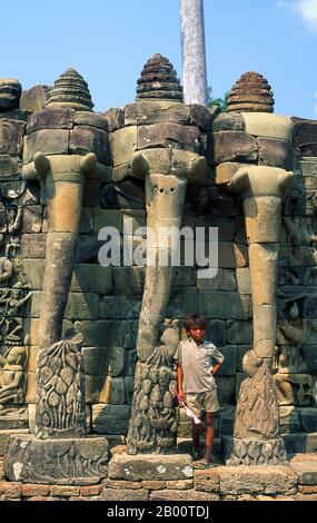 Kambodscha: Junge auf der Terrasse der Elefanten, Angkor Thom. Die Terrasse der Elefanten wurde von König Jayavarman VII verwendet, um seine siegreiche Armee zu überprüfen. Angkor Thom, was ‘die große Stadt’ bedeutet, liegt eine Meile nördlich von Angkor Wat. Es wurde im späten 12. Jahrhundert von König Jayavarman VII. Erbaut und umfasst eine Fläche von 9 km², in denen sich mehrere Denkmäler aus früheren Epochen sowie die von Jayavarman und seinen Nachfolgern. Es wird angenommen, dass es eine Bevölkerung von 80,000-150,000 Menschen erhalten haben. Stockfoto