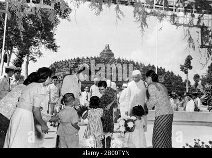 Indonesien: Präsident Sukarno und der indische Premierminister Jawaharlal Nehru beobachten, wie Indira Gandhi während eines Besuchs in Borobudur Blumen empfängt. Sukarno wurde am 6. Juni 1901 in Blitar, Ost-Java, geboren. Sein Name war Kusno Sosrodihardjo, aber er wurde nach javanesischem Brauch umbenannt, nachdem er eine Kinderkrankheit überlebt hatte. Sein Name wird häufig Soekarno nach der niederländischen Schreibweise geschrieben. Am 4. Juli 1927 gründeten Sukarno und einige Freunde das Partai Nasional Indonesia (PNI), um für die Unabhängigkeit Indonesiens zu kämpfen. Sukarno wurde 1930 als politischer Gefangener verurteilt, aber 1931 freigelassen. Stockfoto