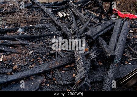 Brandfolgen. Völlig verbranntes Holzhaus Stockfoto