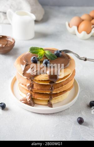 Süße hausgemachte Pfannkuchen mit Schokolade und Blaubeere auf leichtem Tisch. Nahaufnahme. Stockfoto