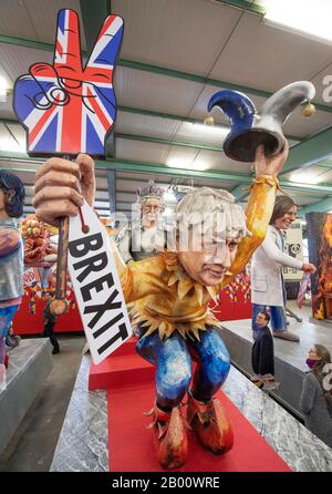 Mainz, Deutschland. Februar 2020. Der britische Premierminister Boris Johnson wird mit einem "Brexit"-Schild und einer Narrenkappe in der Hand dargestellt, die vor der Königin kauern, während sie die Motivwagen für den Rosenmontagszug enthüllt. Eine große Anzahl der Wagen greift dieses Jahr wieder politische Themen auf. Kredit: Boris Roessler / dpa / Alamy Live News Stockfoto