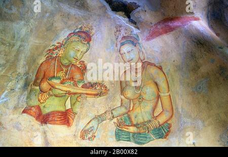 Sri Lanka: Sigiriyas 'Cloud Maidens' schmücken die Felswand hoch oben über der umliegenden Landschaft. Sigiriya (Löwenfelsen) ist eine alte Felsenfestung und Palastruine im zentralen Matale Bezirk von Sri Lanka, umgeben von den Resten eines ausgedehnten Netzes von Gärten, Stauseen und anderen Strukturen. Sigiriya wurde während der Herrschaft von König Kasyapa I. (CE 477 – 495) erbaut und nach seinem Tod als buddhistisches Kloster bis zum 14. Jahrhundert genutzt. Stockfoto