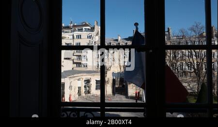 Französische Flagge, die im Wind weht, Blick vom d'Orsay Museum, Paris, Frankreich, durch Fensterglas verzerrte Gebäude. Stockfoto