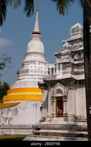 Thailand: Der Hauptchedi und der Kulai Chedi, Wat Phra Singh, Chiang Mai, Nordthailand. Wat Phra Singh oder, um ihm seinen vollen Namen zu geben, Wat Phra Singh Woramahaviharn, wurde zuerst um 1345 von König Phayu, 5. König der Mangrai Dynastie errichtet. König Mengrai gründete die Stadt Chiang Mai (was "neue Stadt" bedeutet) im Jahr 1296, und es folgte Chiang Rai als Hauptstadt des Lanna Königreiches. Chiang Mai wird manchmal als 'Chiengmai' oder 'Chiangmai' geschrieben und ist die größte und kulturell bedeutsamste Stadt im Norden Thailands. Stockfoto