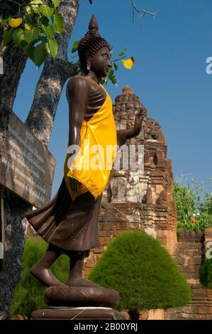 Thailand: Stehender Buddha in der Nähe der Khmer Schreine, Wat Kamphaeng Laeng, Phetchaburi. Wat Kamphaeng Laeng war ursprünglich ein 12th Jahrhundert Khmer Hindu Ort der Anbetung, später zu einem buddhistischen Tempel. Phetchaburi markierte wahrscheinlich auch die südlichste Ausdehnung des Khmer-Reiches. Stockfoto