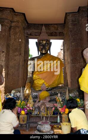 Thailand: Gläubige werfen sich vor einem Buddha in einem der Khmer-Schreine im Wat Kamphaeng Laeng, Phetchaburi nieder. Wat Kamphaeng Laeng war ursprünglich ein 12th Jahrhundert Khmer Hindu Ort der Anbetung, später zu einem buddhistischen Tempel. Phetchaburi markierte wahrscheinlich auch die südlichste Ausdehnung des Khmer-Reiches. Stockfoto