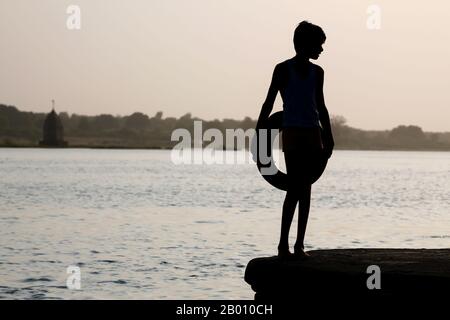 Kleiner Junge in Indien, der am Fluss spielt Stockfoto