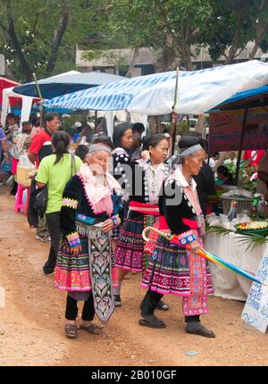 Thailand: Ältere Hmong-Frauen durchgehen den Markt bei den Hmong-Neujahrsfeiern, Chiang Mai, Nordthailand. Das Hmong Neujahr findet in der Regel im November oder Dezember statt (traditionell am Ende der Erntezeit). Die Hmong sind eine asiatische ethnische Gruppe aus den Bergregionen China, Vietnam, Laos und Thailand. Hmong sind auch eine der Untergruppen der Miao-Ethnie in Südchina. Hmong Gruppen begannen eine allmähliche Wanderung nach Süden im 18th Jahrhundert aufgrund von politischen Unruhen und mehr Ackerland zu finden. Stockfoto