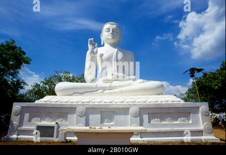 Sri Lanka: Riesiger sitzender Buddha in Ambasthala Dagoba, Mihintale. Mihintale ist ein Berggipfel in der Nähe von Anuradhapura, der von Sri Lankans als Ort einer Begegnung zwischen dem buddhistischen Mönch Mahinda und König Devanampiyatissa geglaubt wird, der die Präsenz des Buddhismus in Sri Lanka einweihte. Es ist jetzt ein Wallfahrtsort und der Ort von mehreren religiösen Denkmälern und verlassenen Strukturen. Stockfoto