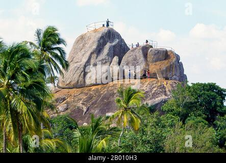 Sri Lanka: Besucher auf der Aradhana Gala (Meditationsfelsen), Mihintale. Mihintale ist ein Berggipfel in der Nähe von Anuradhapura, der von Sri Lankans als Ort einer Begegnung zwischen dem buddhistischen Mönch Mahinda und König Devanampiyatissa geglaubt wird, der die Präsenz des Buddhismus in Sri Lanka einweihte. Es ist jetzt ein Wallfahrtsort und der Ort von mehreren religiösen Denkmälern und verlassenen Strukturen. Stockfoto