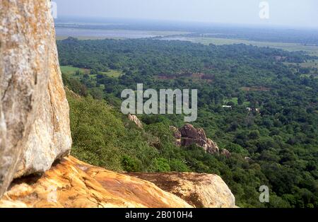 Sri Lanka: Besucher auf der Aradhana Gala (Meditationsfelsen), Mihintale. Mihintale ist ein Berggipfel in der Nähe von Anuradhapura, der von Sri Lankans als Ort einer Begegnung zwischen dem buddhistischen Mönch Mahinda und König Devanampiyatissa geglaubt wird, der die Präsenz des Buddhismus in Sri Lanka einweihte. Es ist jetzt ein Wallfahrtsort und der Ort von mehreren religiösen Denkmälern und verlassenen Strukturen. Stockfoto