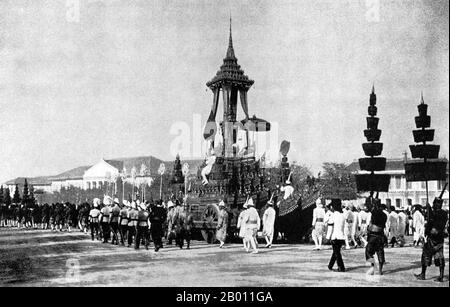 Thailand: Ein Begräbnisbesitz begleitet den Wagen, der die Überreste von König Chulalongkorn, 1911, trägt. Kunstvolle Pavillons und buddhistische Tempel werden traditionell speziell für königliche Beerdigungen in Siam errichtet. Der Leichnam des Verstorbenen wurde einbalsamiert und bewahrt, während die Einäscherungsstätte errichtet wurde. Beerdigungsrituale und eine Trauerperiode könnten Monate oder sogar ein Jahr dauern, bevor die Beerdigung stattfand. Der einbalsamierte Körper wurde dann in einer knieenden Position in einer Goldurne auf einer hohen Bahre in einem kunstvollen Gebäude platziert, das eingeäschert werden sollte. Stockfoto