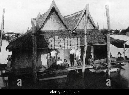 Thailand: Eine siamesische Familie posiert für ein Foto auf ihrem schwimmenden Haus am Chao Phraya Fluss in der Nähe von Bangkok, c. 1900. Um die Wende des 20. Jahrhunderts waren die meisten Siamesen Reisbauern, die entlang der Wasserwege lebten und arbeiteten. Jeder Haushalt hatte ein Boot, von dem schätzungsweise 600,000 die Kanäle und Flüsse von Bangkok befuhren. Rudern wurde von der Rückseite des Bootes aus durchgeführt. Die meisten Häuser wurden aus Holz und Bambus gebaut und auf Stelzen mit einer Leiter zum Wasser gebaut. Stockfoto