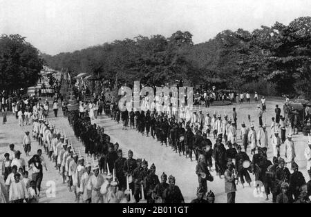 Thailand: Eine Trauerprozession begleitet die Urne, die 1909 die Asche des Prinzen Uruphong in Bangkok trägt. Kunstvolle Pavillons und buddhistische Tempel werden traditionell speziell für königliche Beerdigungen in Siam errichtet. Der Leichnam des Verstorbenen wurde einbalsamiert und bewahrt, während die Einäscherungsstätte errichtet wurde. Beerdigungsrituale und eine Trauerperiode könnten Monate oder sogar ein Jahr dauern, bevor die Beerdigung stattfand. Der einbalsamierte Körper wurde dann in einer knieenden Position in einer Goldurne auf einer hohen Bahre in einem kunstvollen Gebäude platziert, das eingeäschert werden sollte. Stockfoto