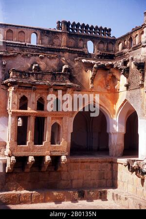 Indien: Queen's Bath, Hampi, Bundesstaat Karnataka. Das Queen's Bath ist Teil der Royal Enclosure und der Tank (Pool) in der Mitte wird angenommen, dass er mit Parfüms und Blumen gefüllt wurde. Hampi ist ein Dorf im nördlichen Bundesstaat Karnataka. Es befindet sich in den Ruinen von Vijayanagara, der ehemaligen Hauptstadt des Vijayanagara-Reiches. Vor der Stadt Vijayanagara ist es weiterhin ein wichtiges religiöses Zentrum, in dem der Virupaksha-Tempel sowie mehrere andere Denkmäler der Altstadt untergebracht sind. Stockfoto