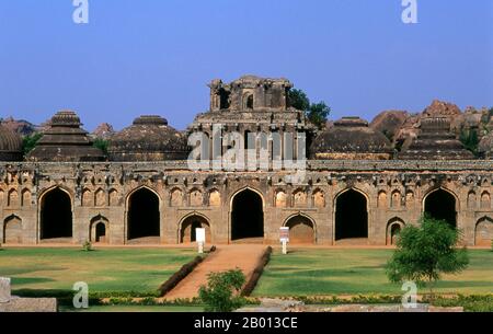 Indien: Elefantenställe, Hampi, Bundesstaat Karnataka. Die Elefantenställe wurden verwendet, um die zeremoniellen Elefanten des königlichen Haushalts zu beherbergen. Die Struktur zeigt einen deutlichen islamischen Einfluss in ihren Kuppeln und gewölbten Toren. Hampi ist ein Dorf im nördlichen Bundesstaat Karnataka. Es befindet sich in den Ruinen von Vijayanagara, der ehemaligen Hauptstadt des Vijayanagara-Reiches. Vor der Stadt Vijayanagara ist es weiterhin ein wichtiges religiöses Zentrum, in dem der Virupaksha-Tempel sowie mehrere andere Denkmäler der Altstadt untergebracht sind. Stockfoto