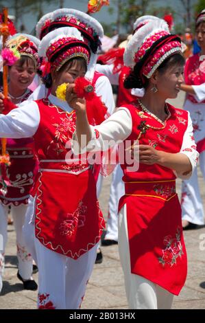 China: Bai-Frauen tanzen beim Bai-Musik- und Tanzfestival in Santa Si (drei Pagoden), Dali, Yunnan. Die Bai oder Baip sind eine der 56 Volksgruppen, die offiziell von der Volksrepublik China anerkannt werden. Die Bai-Bevölkerung lebt hauptsächlich in den Provinzen Yunnan (Dali-Gebiet) und in den benachbarten Provinzen Guizhou (Bijie-Gebiet) und Hunan (Sangzhi-Gebiet). Dali ist die alte Hauptstadt sowohl des Bai-Königreichs Nanzhao, das im 8. Und 9. Jahrhundert in der Region blühte, als auch des Königreichs Dali, das von 937 bis 1253 regierte. Dali liegt in einem einst bedeutenden muslimischen Teil Südchinas. Stockfoto