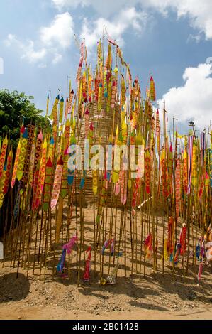 Thailand: Astrologische Banner schmücken den riesigen songkran-Sandchedi im Wat Chetlin, Chiang Mai. In vielen Tempeln werden rund um die Zeit des jährlichen songkran Wasserfestivals riesige Sandchedis gebaut. Die Menschen bringen eine Handvoll Sand in ihren lokalen Tempel und er wird dann in einen Sandchedi geformt. Der mitgebrachte Sand steht symbolisch für den Sand und Schmutz, der im vergangenen Jahr auf den Fußsohlen der Besucher vom Tempel weggetragen wurde. Stockfoto