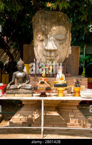 Thailand: Der alte Buddha-Kopf und der Altar wurden für das songkran-Fest auf dem Gelände des Wat Chetlin, Chiang Mai, eingerichtet. Songkran ist das traditionelle thailändische Neujahr und wird vom 13. Bis 15. April gefeiert. Dieses jährliche Wasserfest, das auf Thai als „songkran“ und auf Burma als „Thingyan“ bekannt ist, markiert den Beginn der Regenzeit und wird in Burma, Laos, Thailand und anderen südostasiatischen Ländern, in der Regel im April, gefeiert. Chiang Mai (was „neue Stadt“ bedeutet), manchmal auch als „Chiengmai“ oder „Chiangmai“ geschrieben, ist die größte und kulturell bedeutsamste Stadt im Norden Thailands. Stockfoto