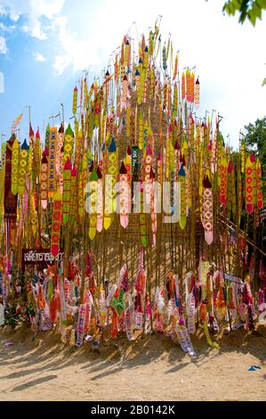 Thailand: Astrologische Banner schmücken den riesigen songkran-Sandchedi im Wat Chetlin, Chiang Mai. In vielen Tempeln werden rund um die Zeit des jährlichen songkran Wasserfestivals riesige Sandchedis gebaut. Die Menschen bringen eine Handvoll Sand in ihren lokalen Tempel und er wird dann in einen Sandchedi geformt. Der mitgebrachte Sand steht symbolisch für den Sand und Schmutz, der im vergangenen Jahr auf den Fußsohlen der Besucher vom Tempel weggetragen wurde. Stockfoto