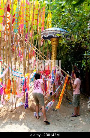 Thailand: Astrologische Banner schmücken den riesigen songkran-Sandchedi im Wat Chetlin, Chiang Mai. In vielen Tempeln werden rund um die Zeit des jährlichen songkran Wasserfestivals riesige Sandchedis gebaut. Die Menschen bringen eine Handvoll Sand in ihren lokalen Tempel und er wird dann in einen Sandchedi geformt. Der mitgebrachte Sand steht symbolisch für den Sand und Schmutz, der im vergangenen Jahr auf den Fußsohlen der Besucher vom Tempel weggetragen wurde. Stockfoto