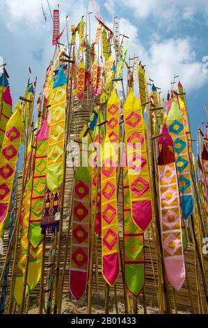 Thailand: Astrologische Banner schmücken den riesigen songkran-Sandchedi im Wat Chetlin, Chiang Mai. In vielen Tempeln werden rund um die Zeit des jährlichen songkran Wasserfestivals riesige Sandchedis gebaut. Die Menschen bringen eine Handvoll Sand in ihren lokalen Tempel und er wird dann in einen Sandchedi geformt. Der mitgebrachte Sand steht symbolisch für den Sand und Schmutz, der im vergangenen Jahr auf den Fußsohlen der Besucher vom Tempel weggetragen wurde. Stockfoto